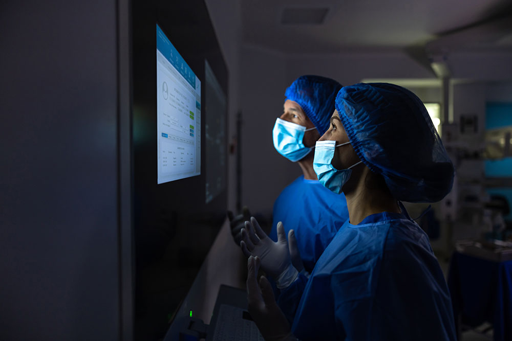 Doctors looking at monitor with masks on