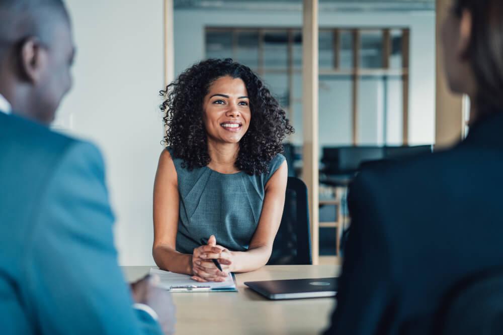 Three people sitting at a business meeting.